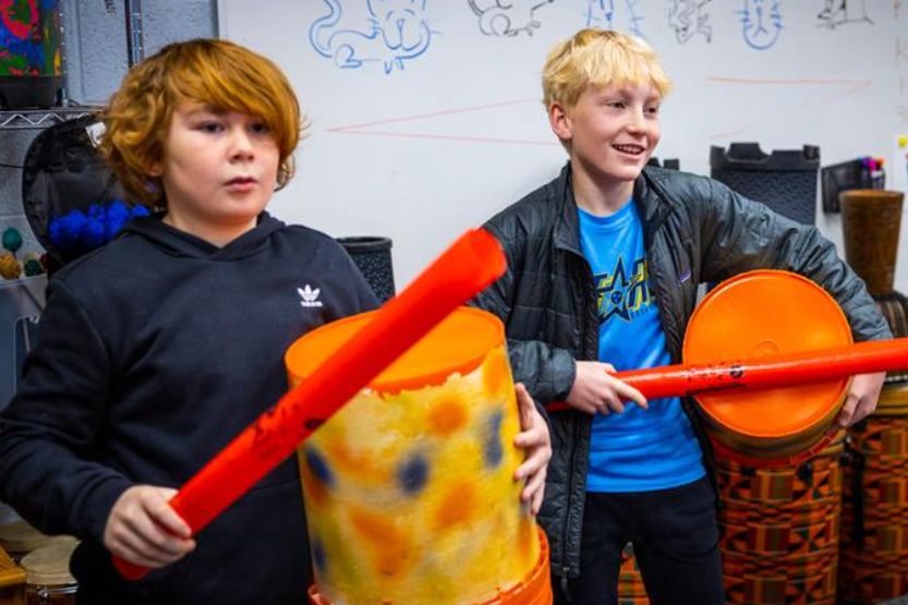 Students play drums in music class